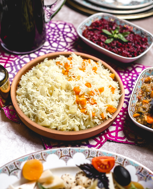 Authentic Arabic vegetable rice with carrots and potatoes served at Layali Riyadh, accompanied by traditional side dishes and dips